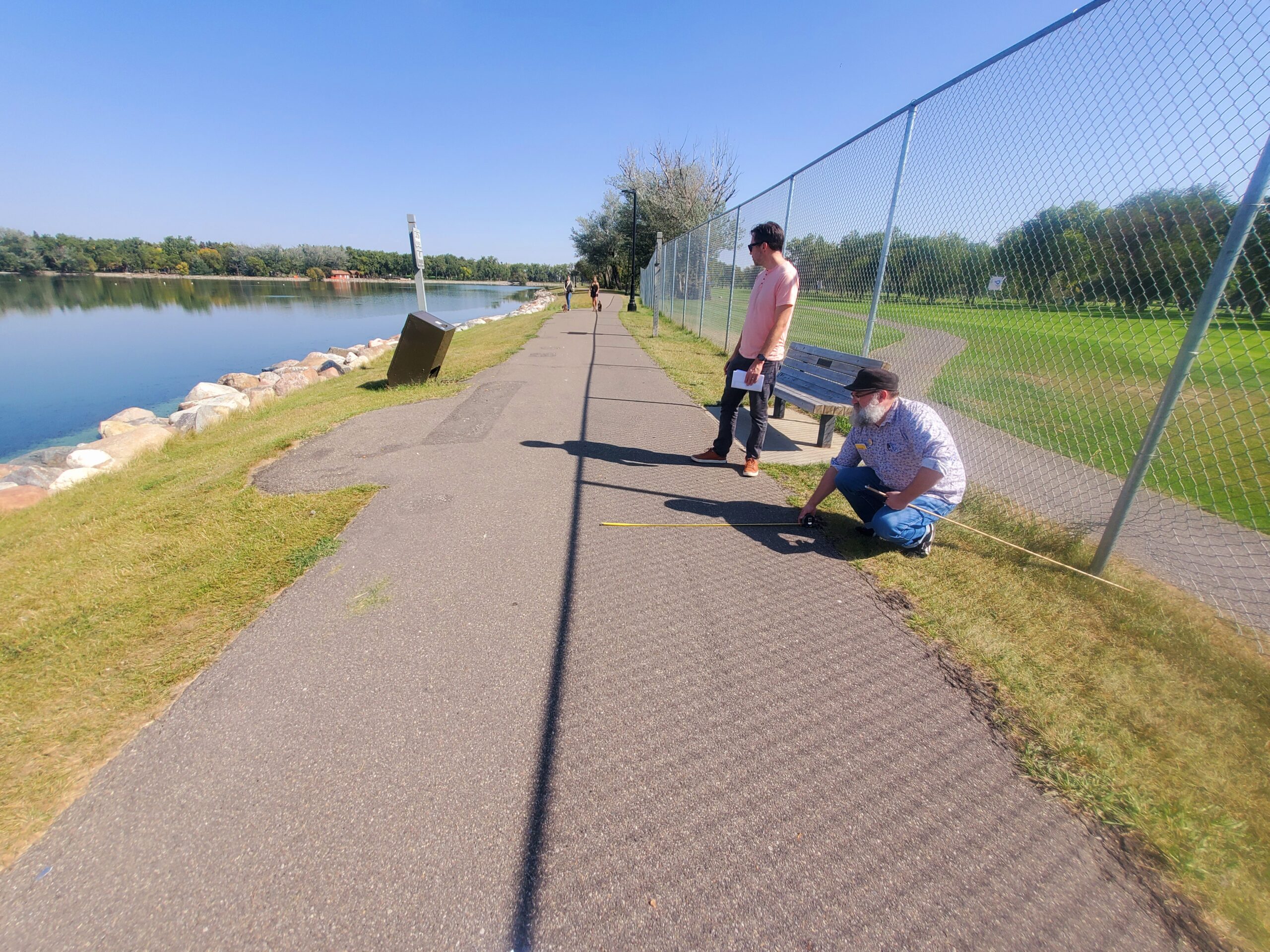 Henderson Lake Asphalt Art Site #1 Artist Eric Dyck surveys the sidewalk on the south side of Henderson Lake Park between the lake and the golf course.